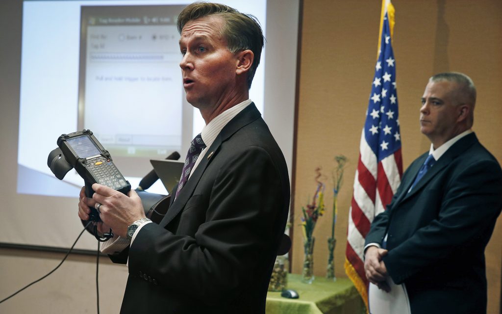 Lewis Koski, left, chief investigator of the Colorado Marijuana Enforcement Division, demonstrates a handheld radio-frequency reader, which is part of its new marijuana inventory tracking system, known as MITS, during a news conference, in Denver, Wednesday, Dec. 11, 2013. Ron Kammerzell, the senior director of enforcement for the Colorado Dept. of Revenue, is pictured at right. Roughly 150 Colorado medical marijuana dispensaries are hoping to begin selling to recreational users when it becomes legal to sell on Jan. 1, 2014. (AP Photo/Brennan Linsley)