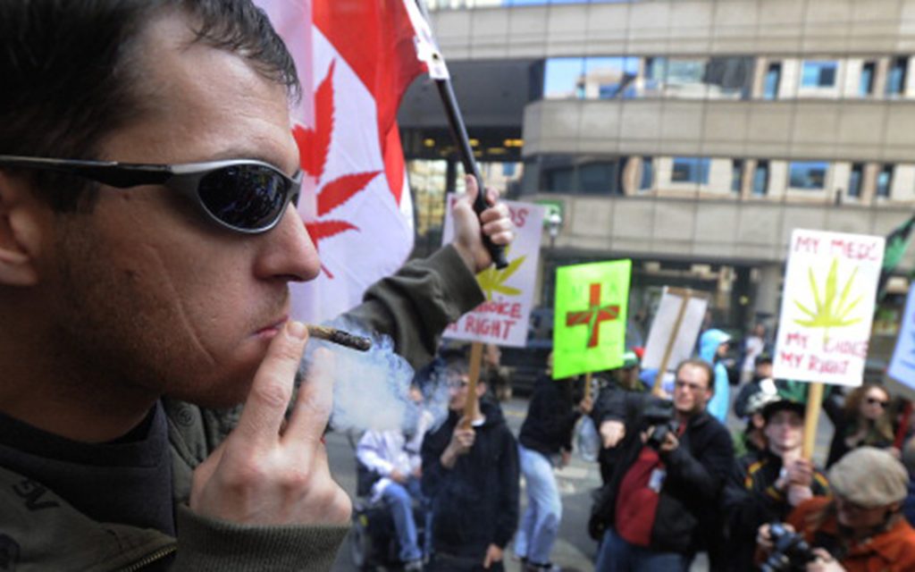 April 11, 2010. Christopher Goodwin smokes cannabis outside police headquarters on College St. to protest a recent raid on their medical marijuana club. (Colin McConnell/Toronto Star/Getty Images)