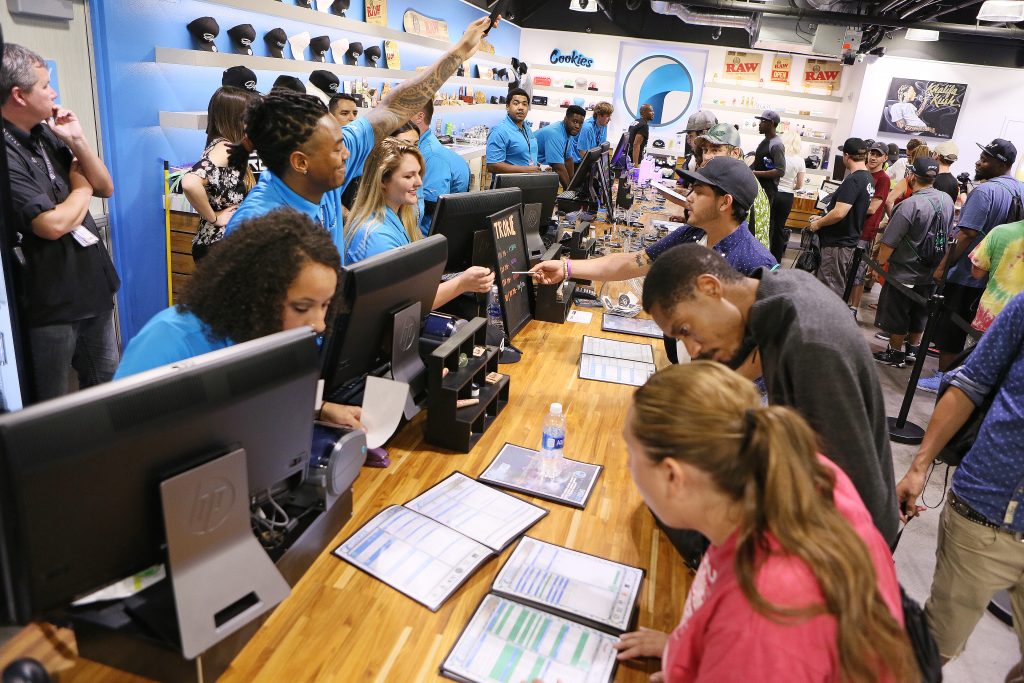 While daytime crowds were a bit smaller on Saturday, long lines of customers kept budtenders scrambling. Here, shortly after midnight, staff members at The Reef Dispensary attend to patrons shortly after the beginning of legal, adult-use sales. (Ronda Churchill for Leafly)